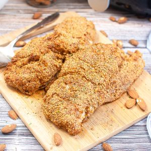 Almond crusted chicken fully cooked on a cutting board