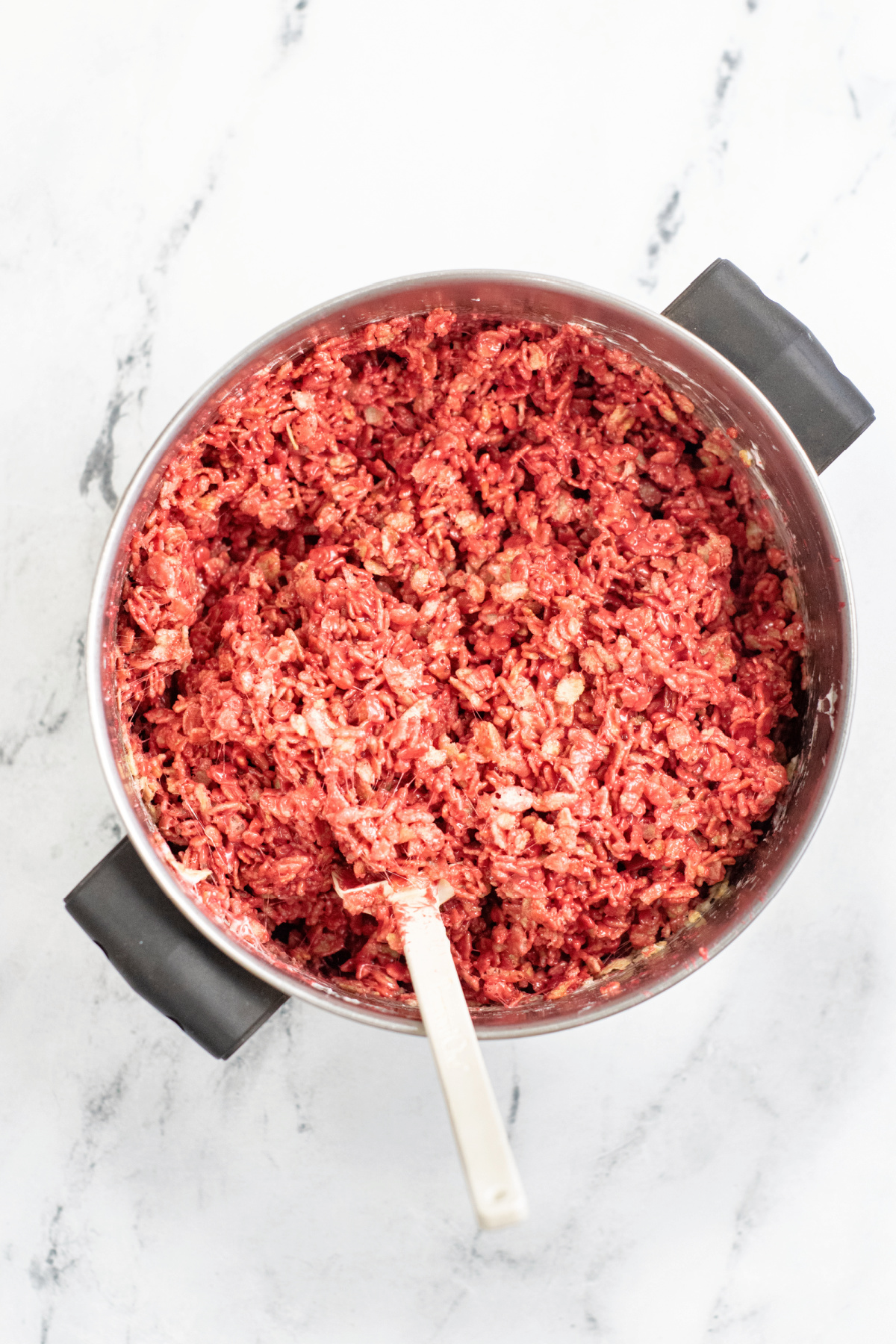 Mix Red Velvet Rice Krispie Treats in a pan with rubber spatula