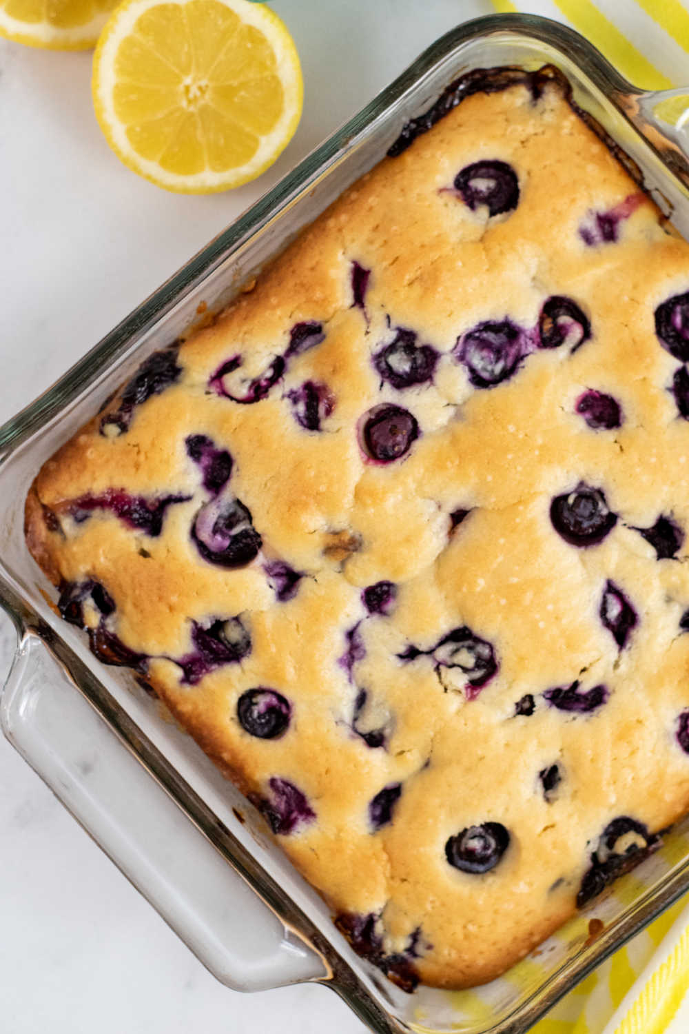 A square glass pan with a blueberry sour cream coffee cake in it. 