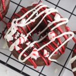 Chocolate cake donut on a wire rack decorated with peppermint and white and red chocolate.