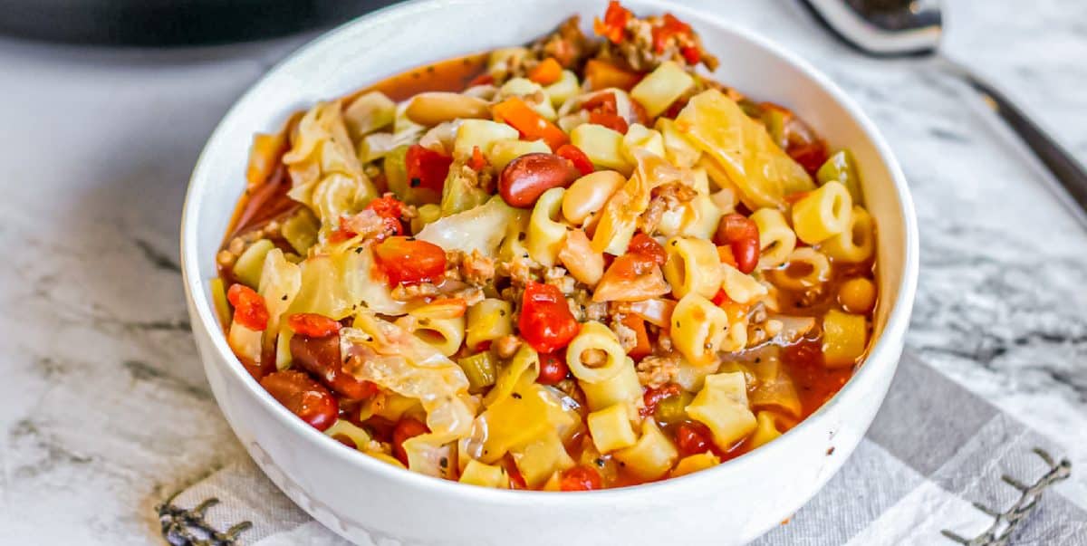 Close up wide view of pasta fagioli soup in a bowl on a counter.