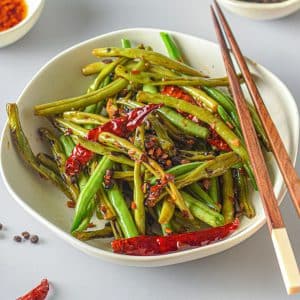 green beans and red chiles in bowl with chop sticks