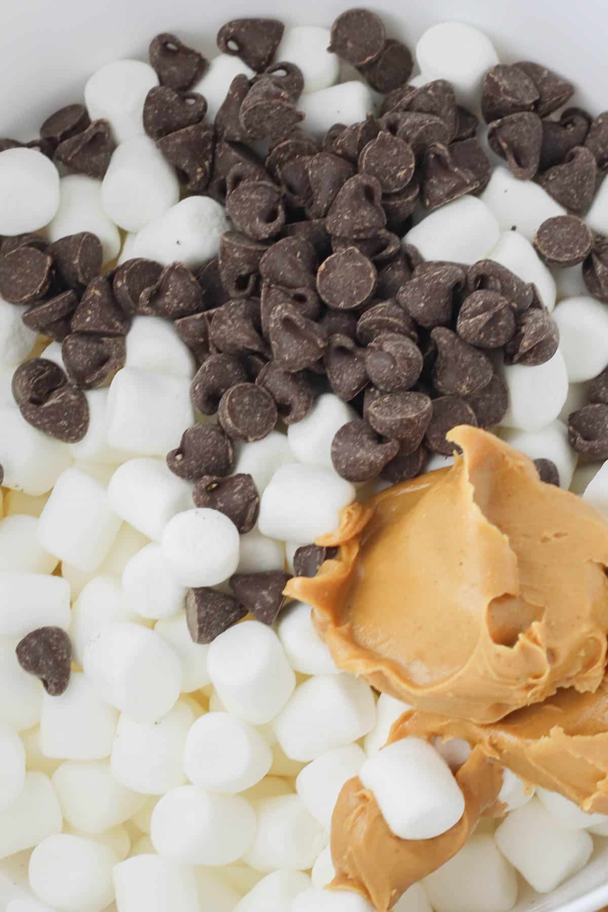 white bowl of mini marshmallows, peanut butter and chocolate chips.