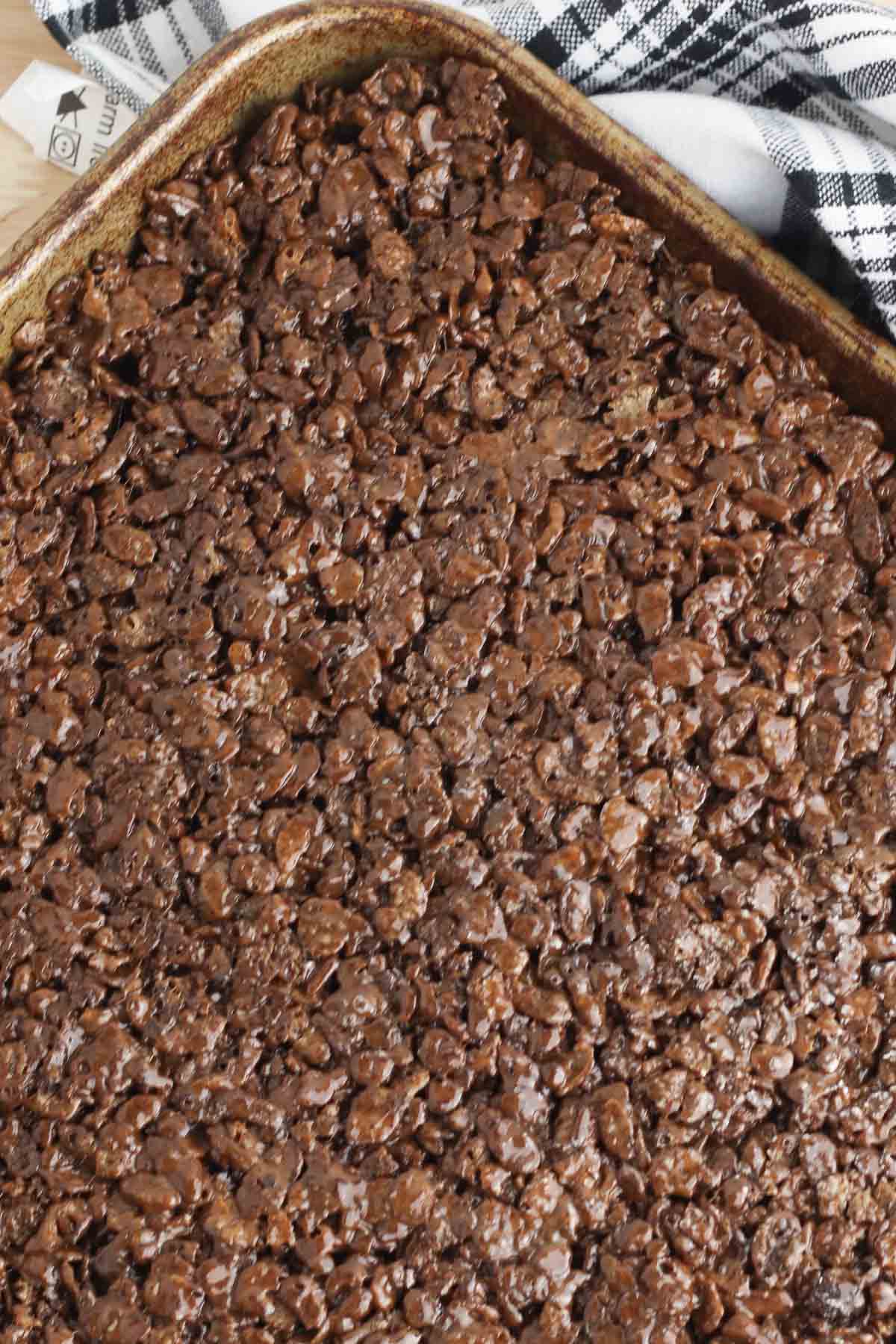 cocoa pebbles cereal bar mixture pressed into a pan.