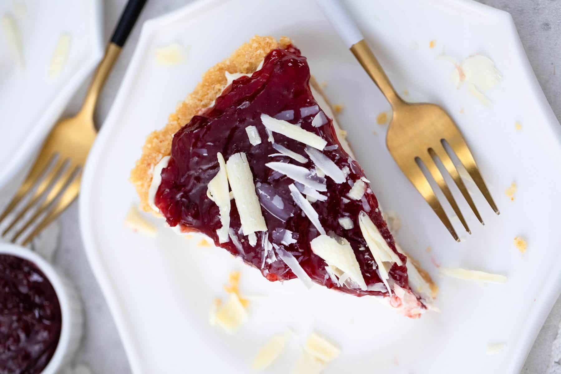 Cherry cheesecake on a white plate with a fork