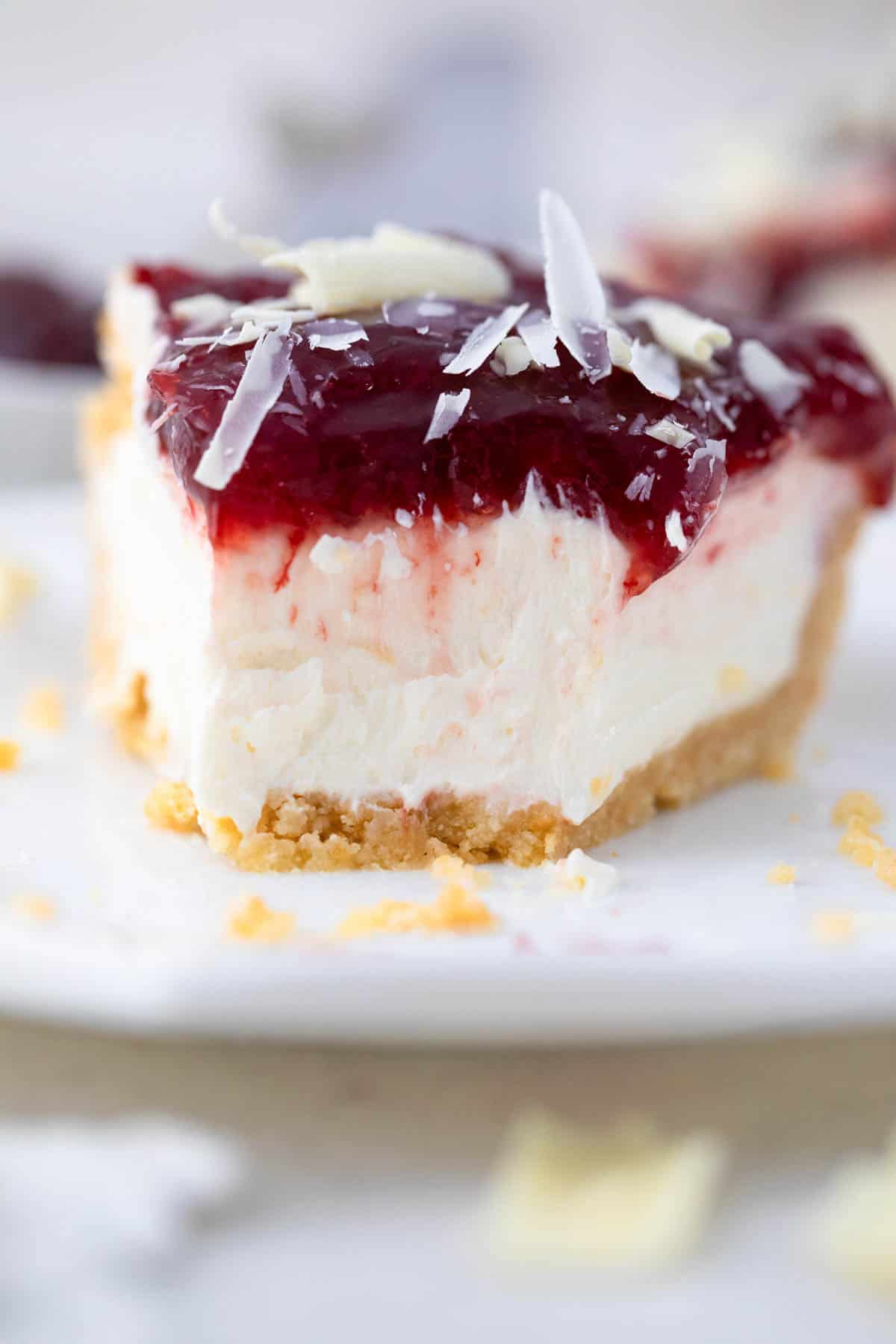 Slice of cherry cheesecake with a bite taken out of it