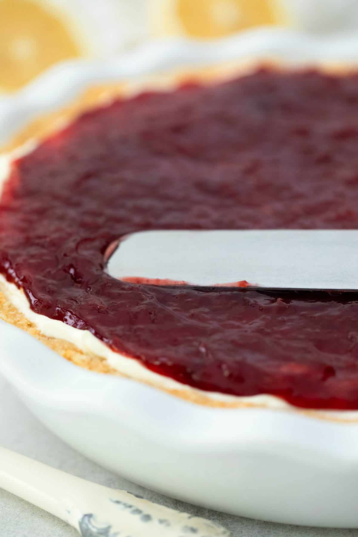 Cherry pie filling being spread with a spatula