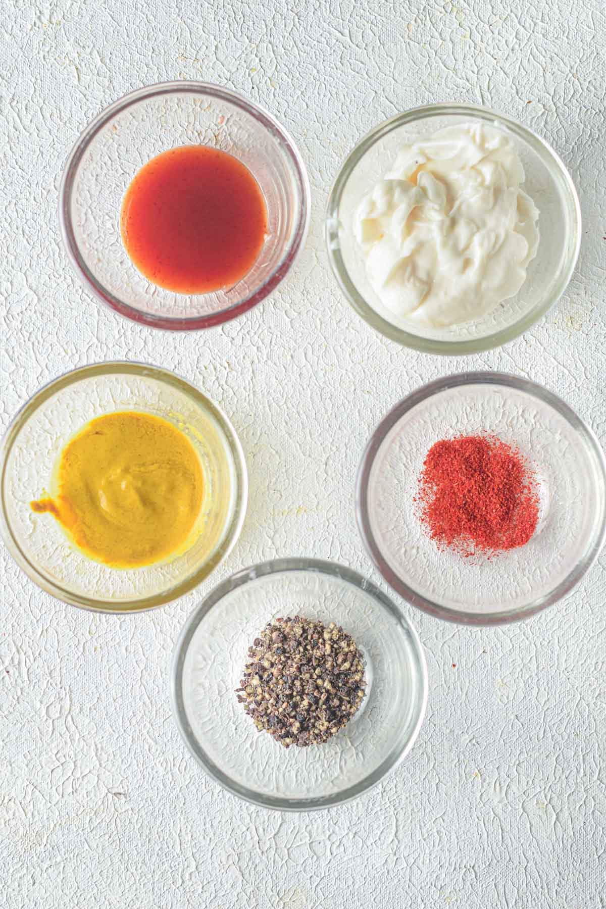 dressing ingredients in small glass bowls on counter