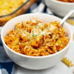 Cheesy baked rotini in a bowl with a fork.