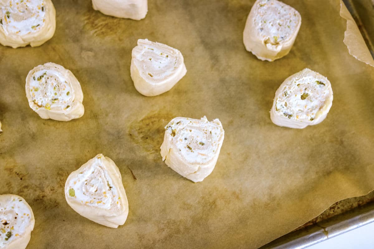 unbaked jalapeno rolls on a parchment paper-lined cookie sheet.