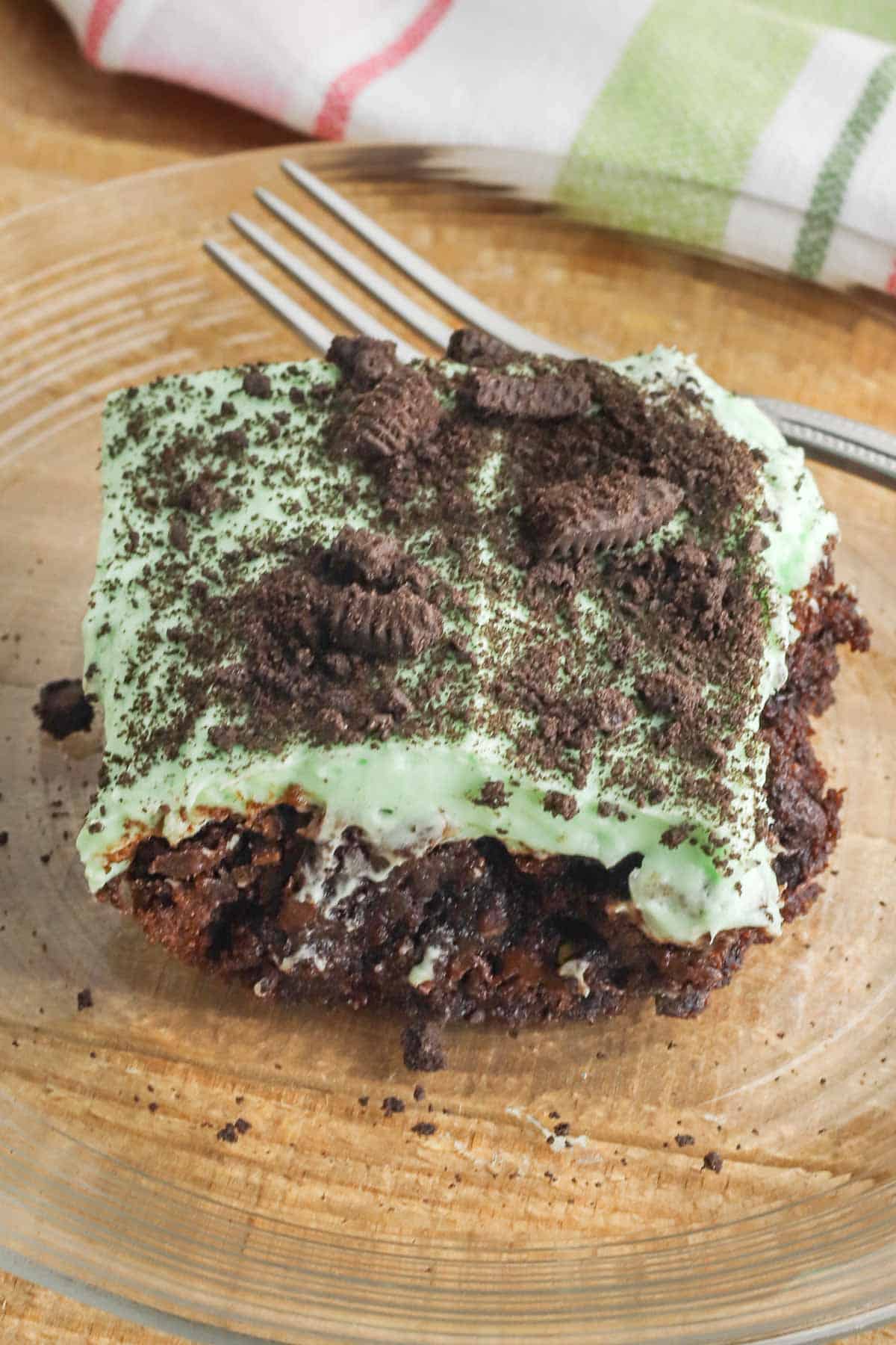 grasshopper brownie with a green fluffy layer topped with chocolate cookie crumbs.